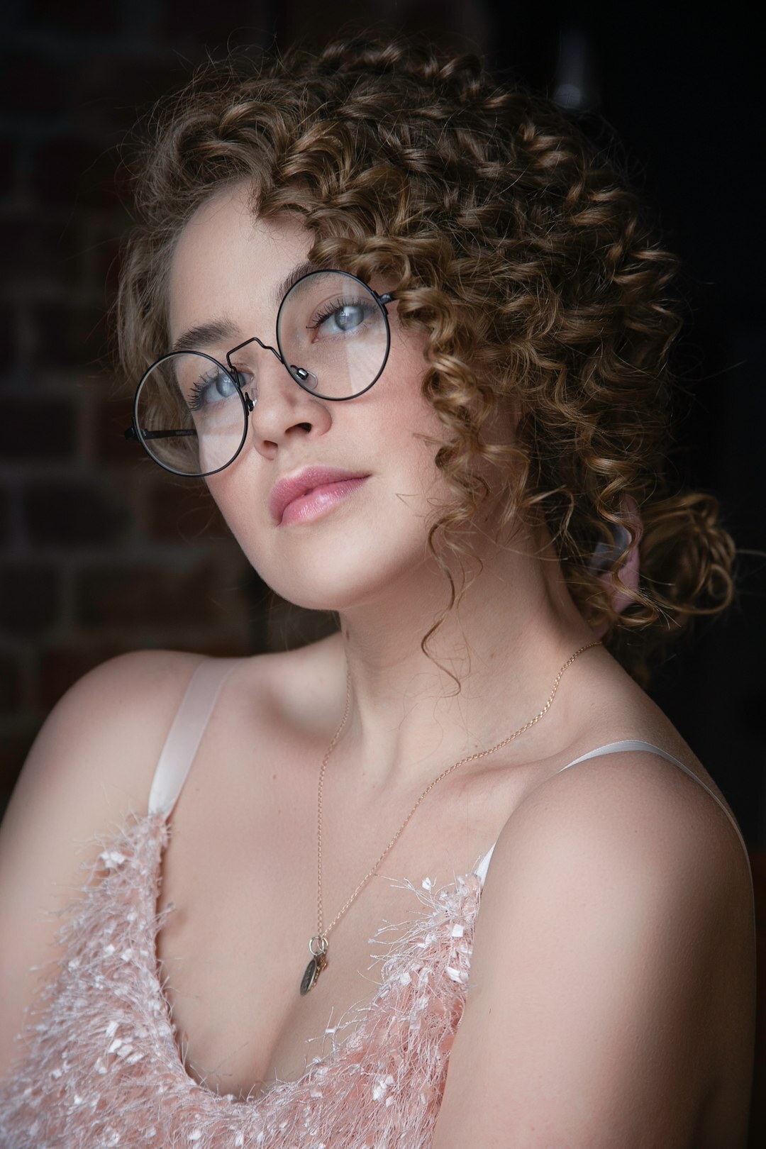 Studio portrait of a woman with glasses and curly hair