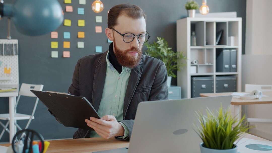 Analyst reviewing market charts on a laptop in a modern office