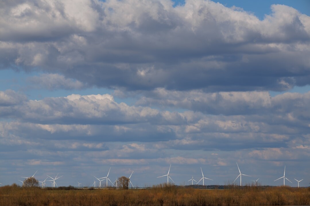 Wind turbines in a green field under a cloudy sky